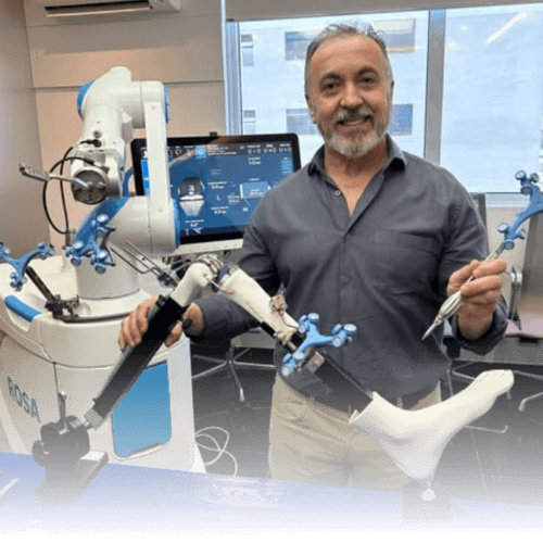 Dr. João Carlos Schleder operando com tecnologia robótica avançada em centro cirúrgico